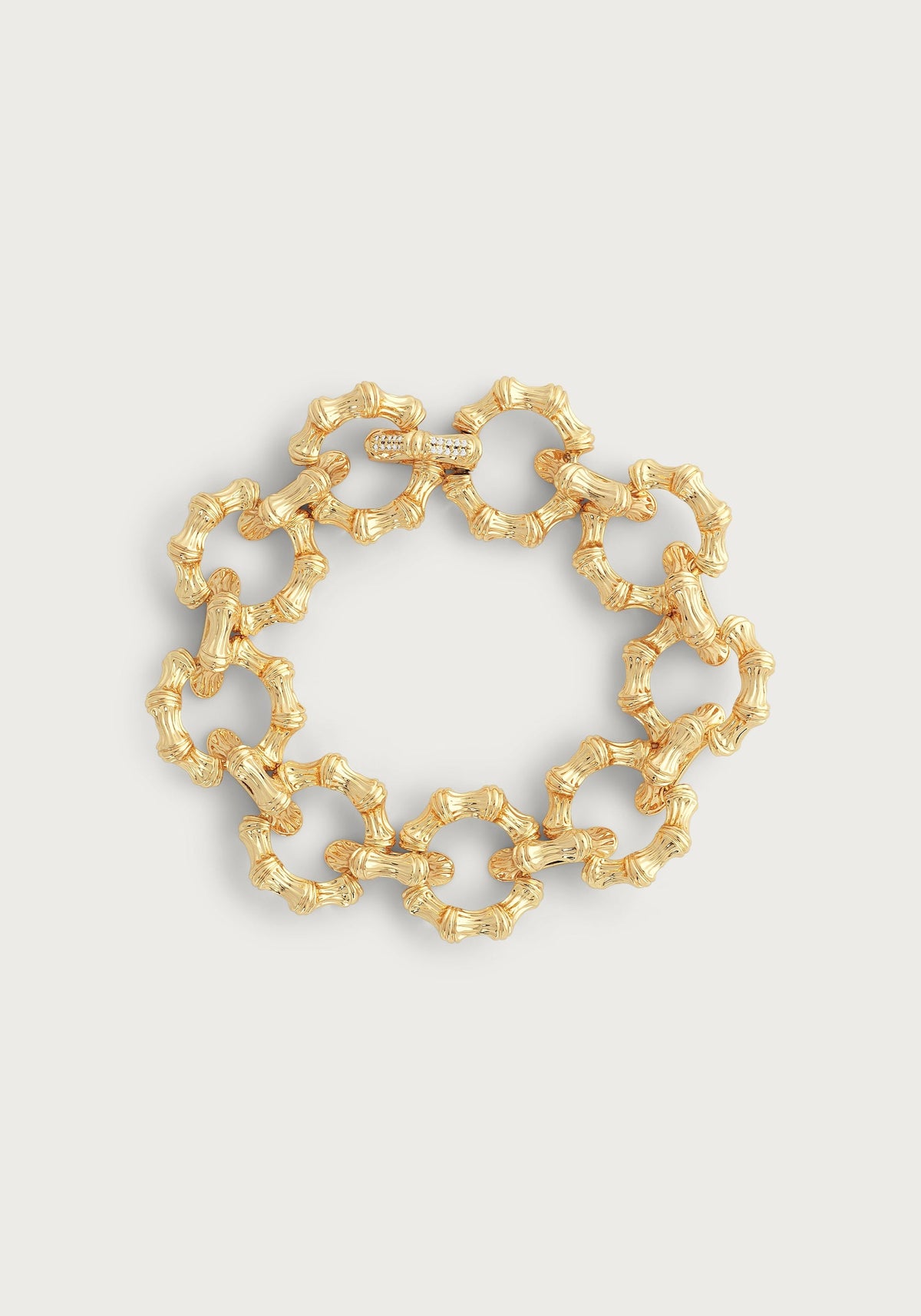 Gold-plated bamboo-inspired chain bracelet with a crystal pavé closure on a white background.