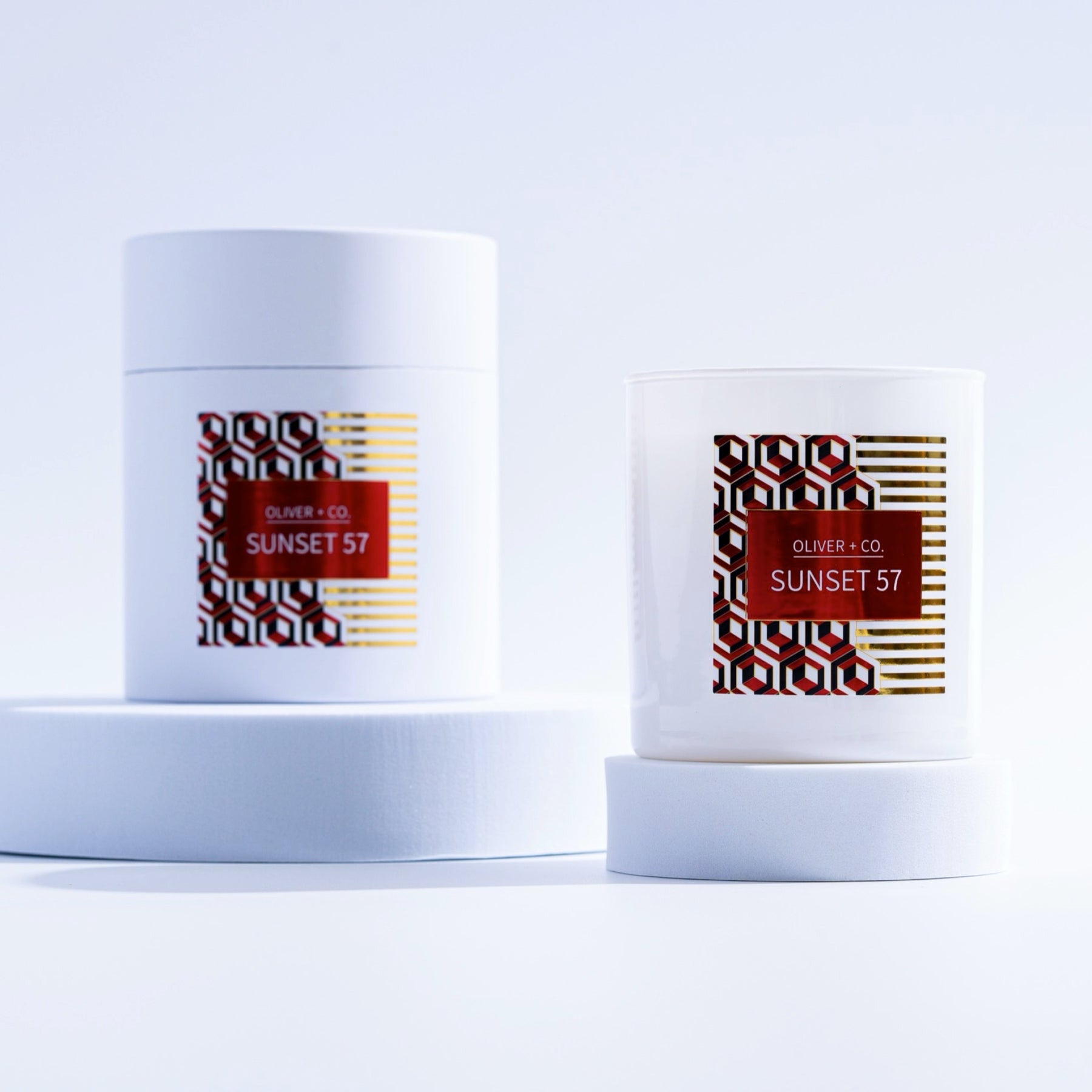 12 oz Signature Candle in white glass and matching cylindrical box with red Sunset 57 label.