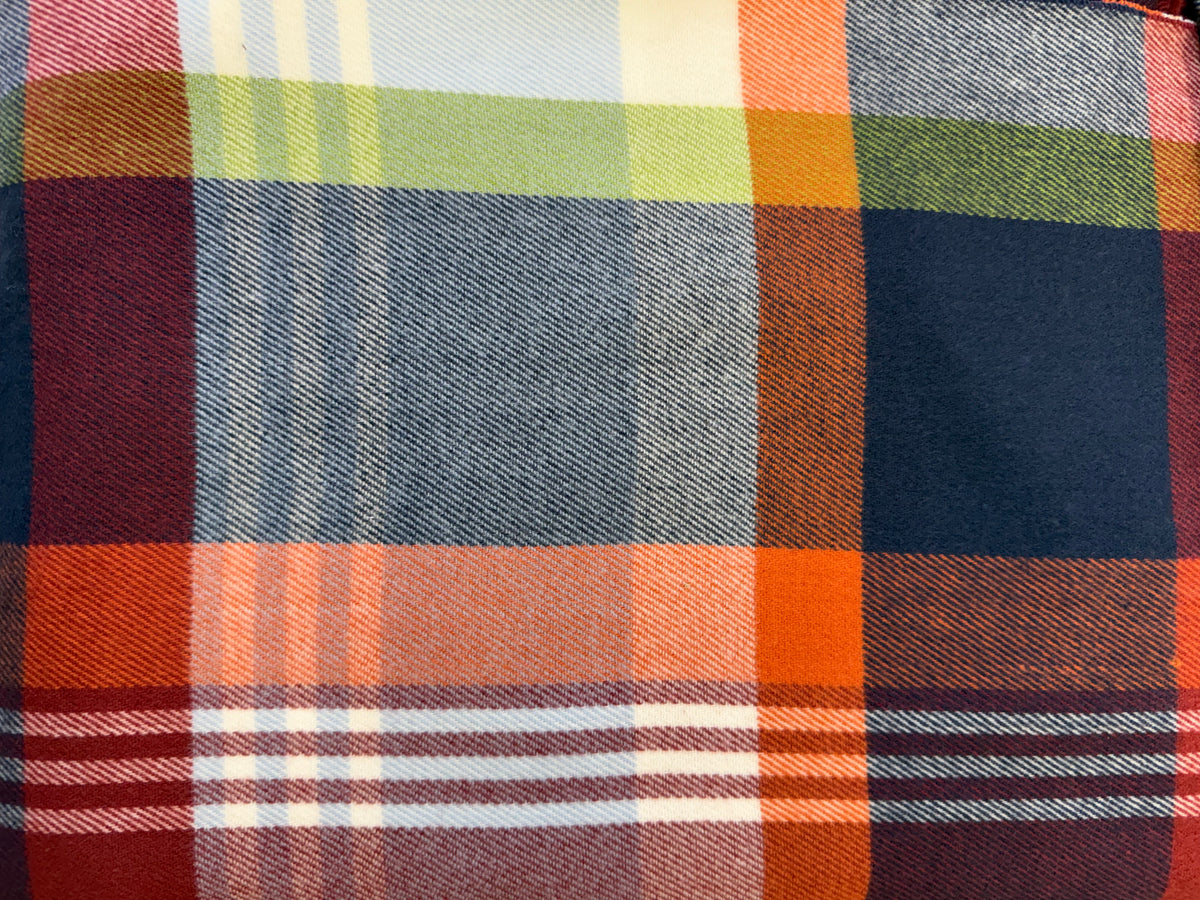 Close-up of a Scottish plaid cashmere scarf with orange, blue, green, and red checkered patterns.