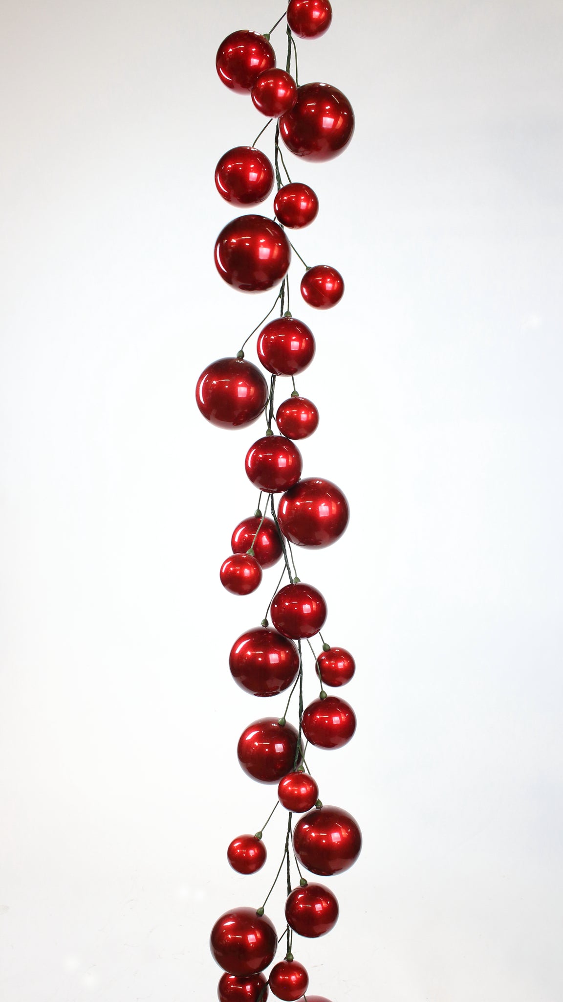Red candy apple ball garland with ornaments in sizes two to four inches.