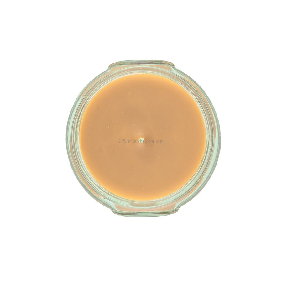 Top-down view of a 3.4oz Tyler Candle in a clear glass jar with light tan wax and a single wick.