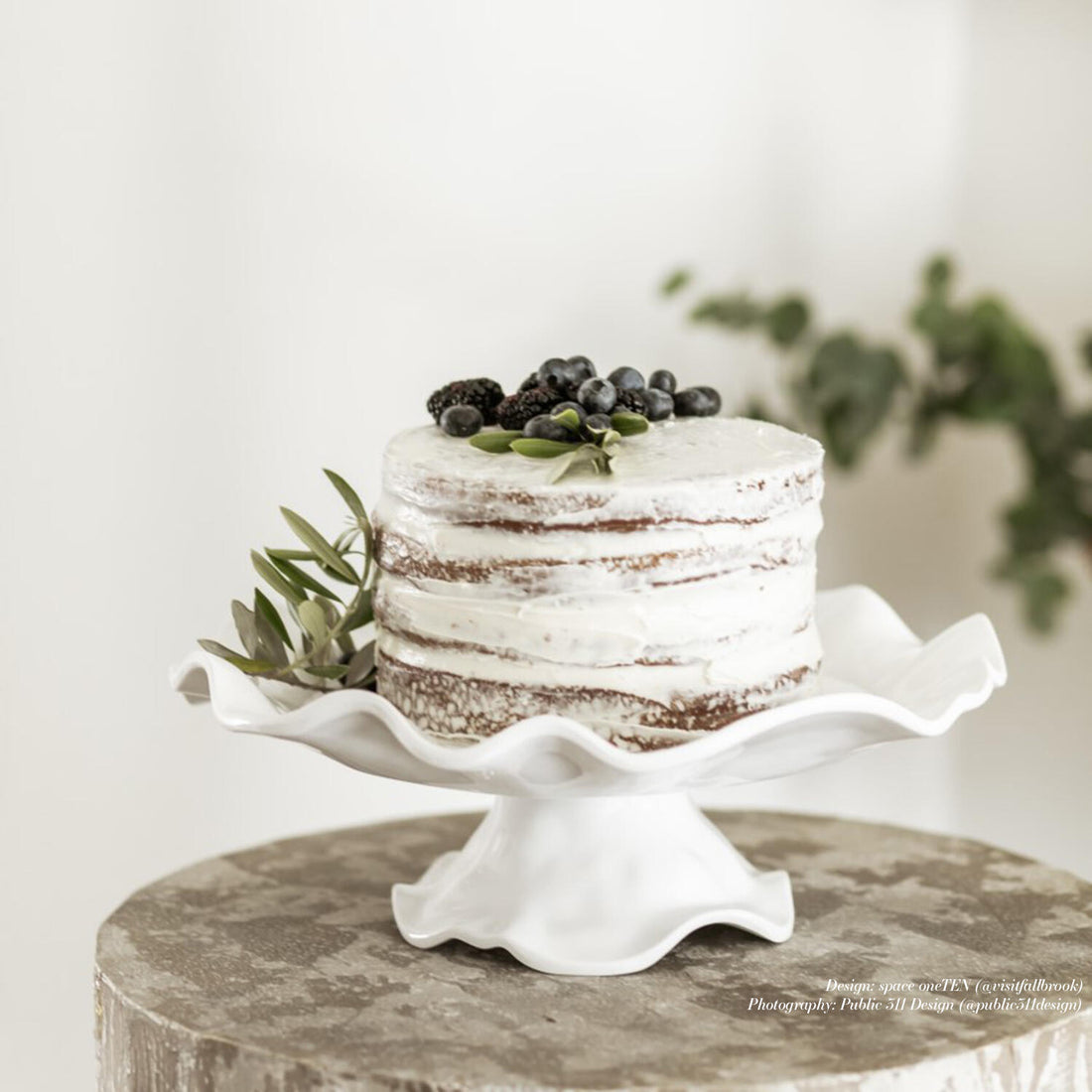 White pedestal cake plate with a raised center column on an oval base.