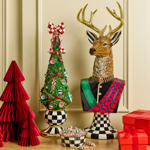 Timeless Tartan Illuminated Topiary Tree with a red bow on a checkered base next to a deer bust.