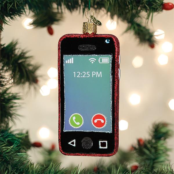 Red glittery glass smartphone ornament with a call screen hanging on a Christmas tree.