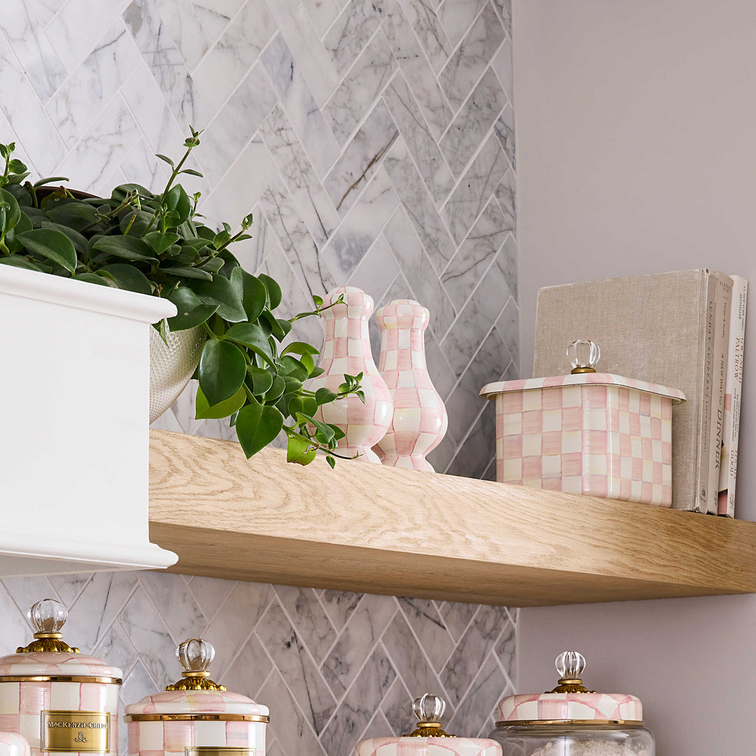 Rosy Check Large Salt & Pepper Shakers on a wooden shelf next to a plant and canisters.