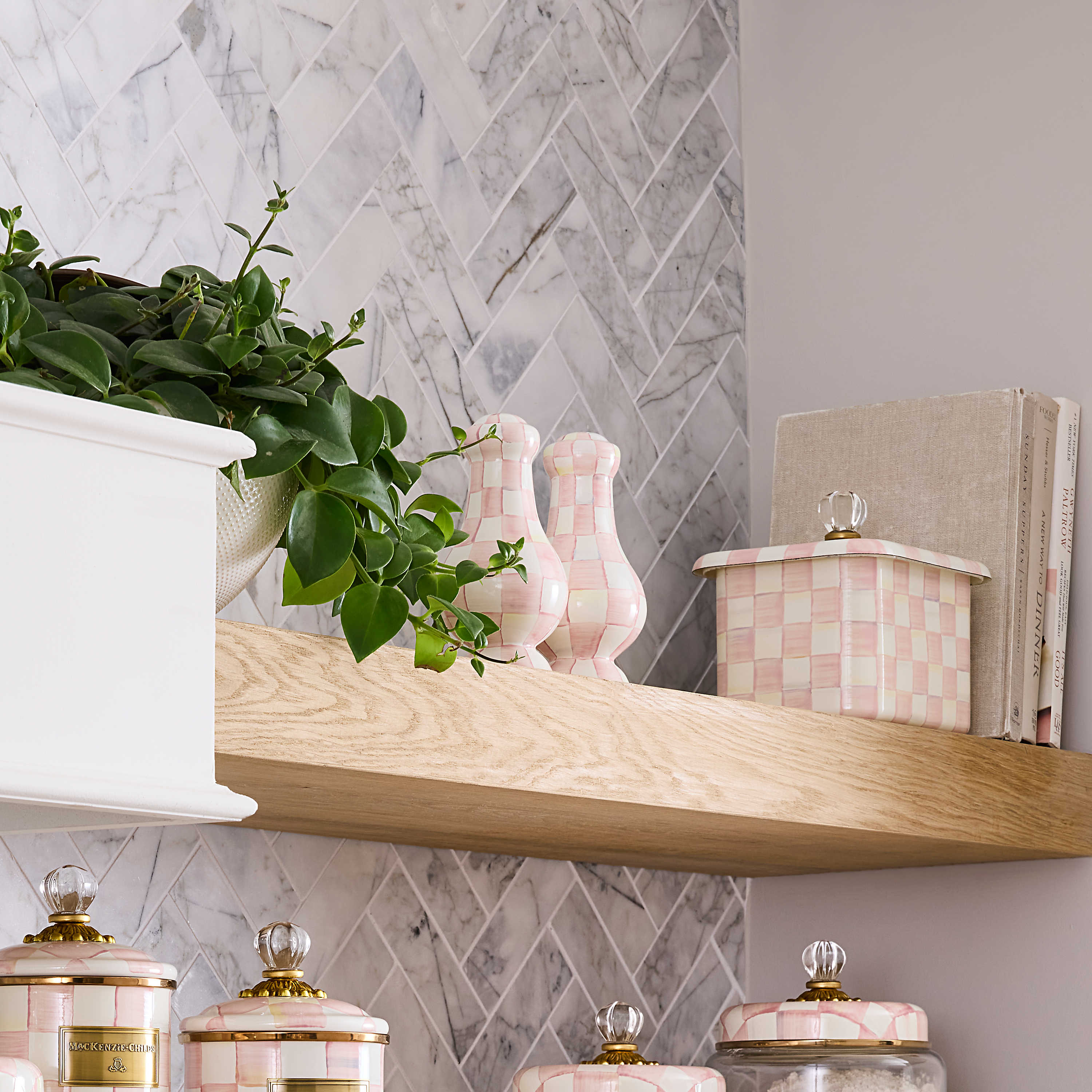 Rosy Check Large Salt & Pepper Shakers on a wooden shelf next to a plant and canisters.