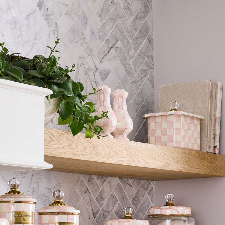 Rosy Check Large Salt & Pepper Shakers on a wooden shelf next to a plant and canisters.