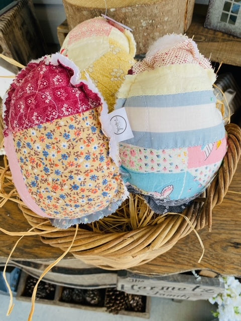 Vintage fabric Easter egg with quilted patchwork patterns in warm tones.