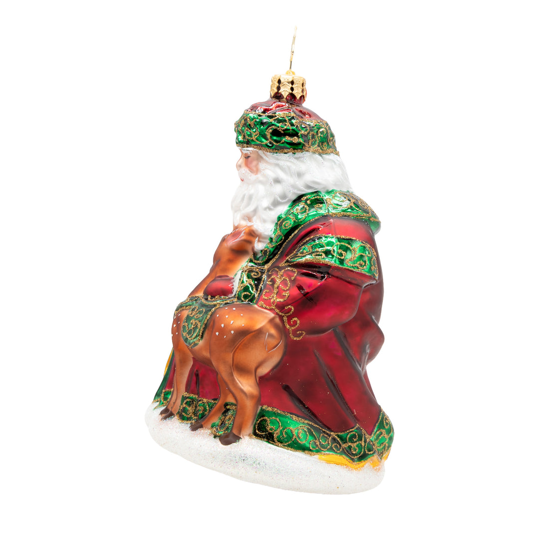 Glass Santa ornament in a red robe with green trim, holding a small brown fawn.