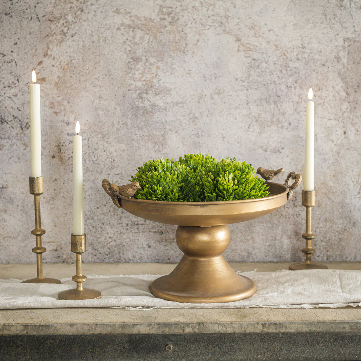 Raised gold metal tray with bird silhouettes on a circular pattern