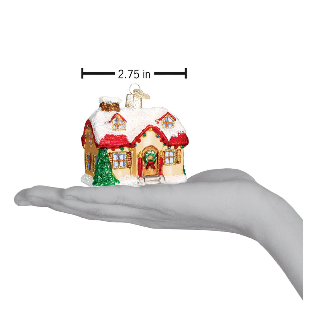 Holiday Home Ornament, a glittery snow-covered cottage being held in a hand for scale.