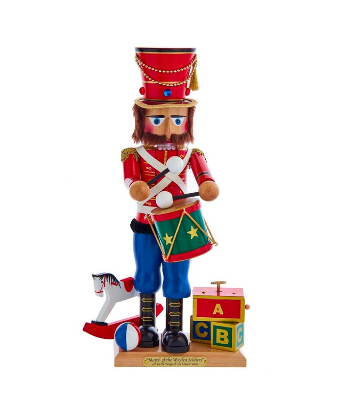 Wooden marching toy soldier nutcracker playing March Of The Wooden Soldier tune with drum and surrounded by toys