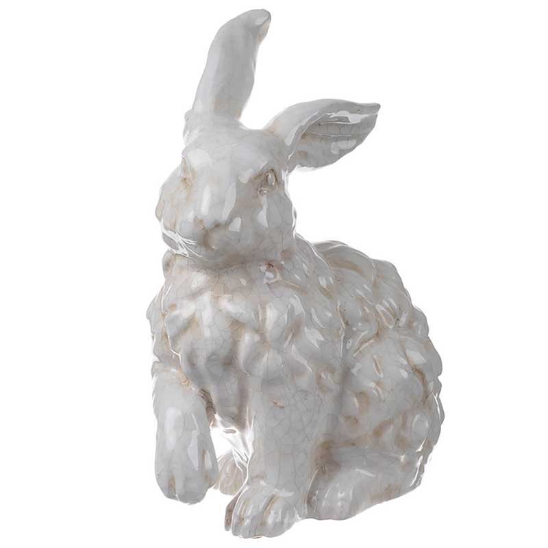 Distressed white ceramic bunny statue sitting with right ear and paw raised.