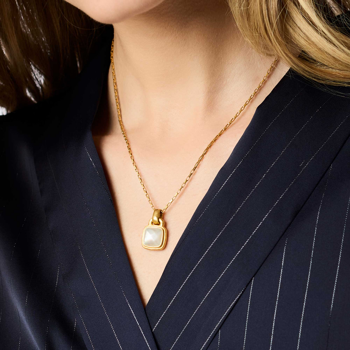 Woman wearing the Sahara Solitaire Necklace, a 24K gold plate chain with a square glass pendant.