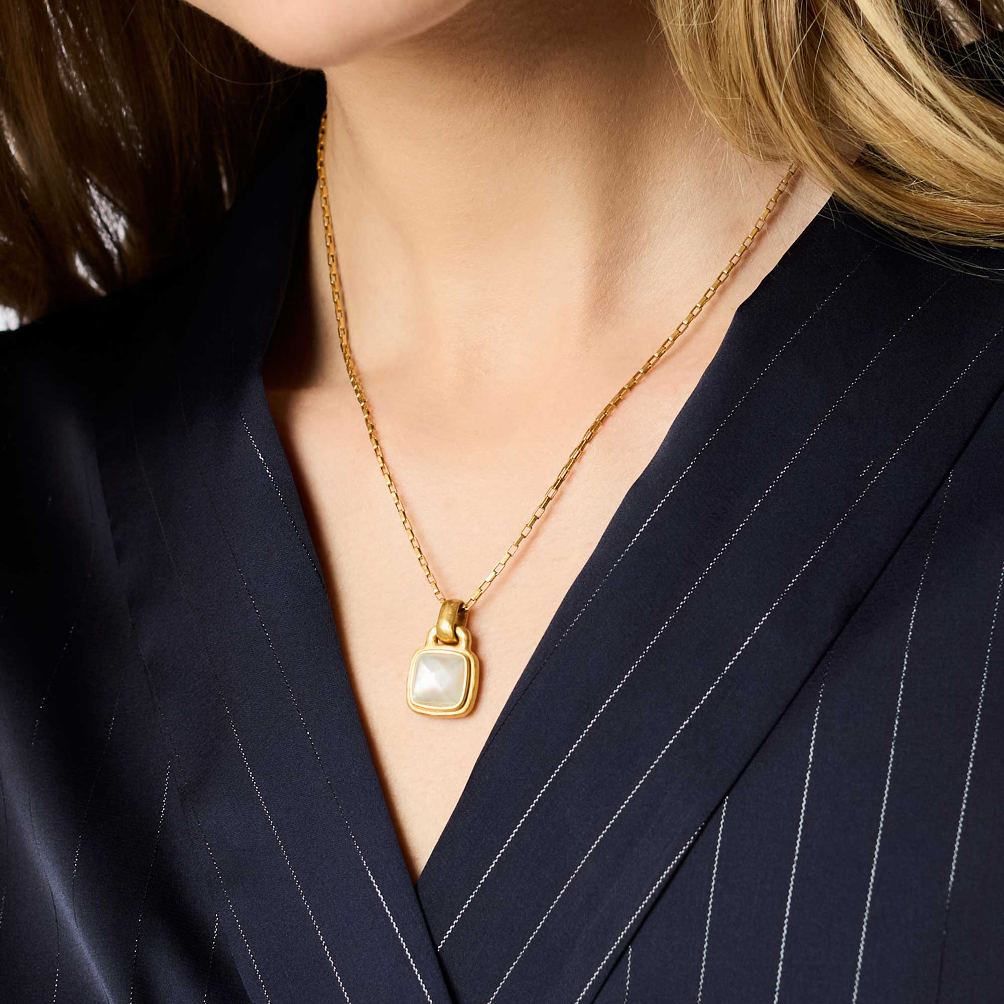 Woman wearing the Sahara Solitaire Necklace, a 24K gold plate chain with a square glass pendant.