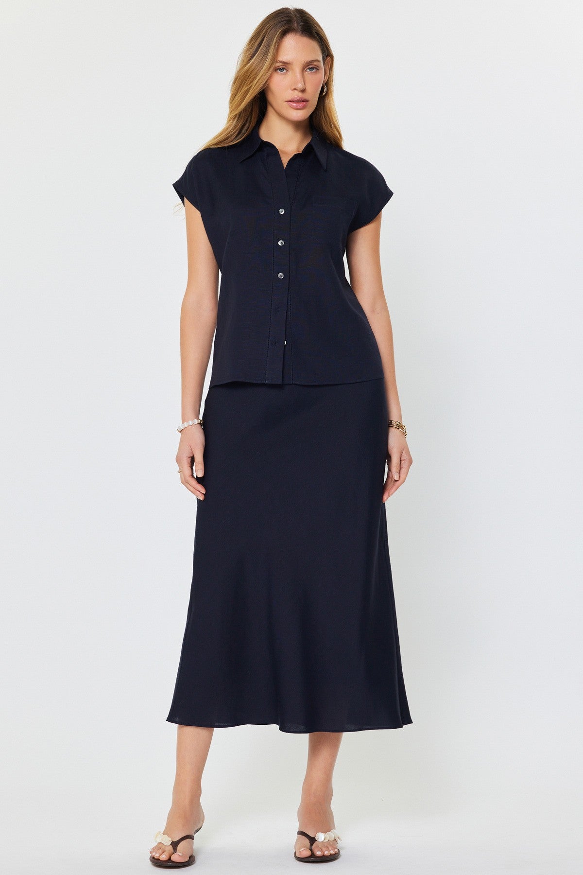 Madison cap-sleeve button-down blouse in a light neutral linen-rayon blend with a relaxed silhouette.