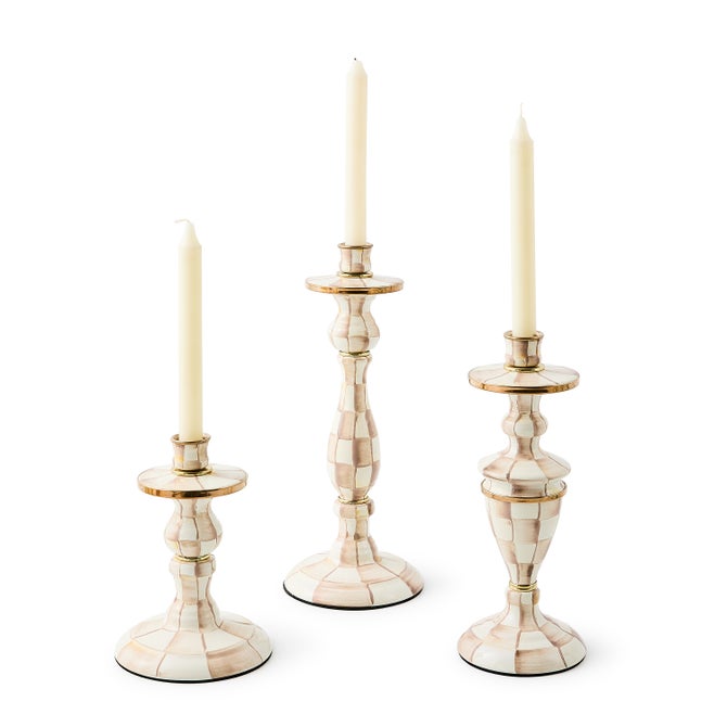 Three hand-painted check candlesticks in varying heights with brass accents and white taper candles.