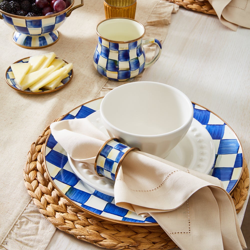 Royal Check Enamel Charger Plate on a woven placemat with a matching bowl, mug, and napkin ring.