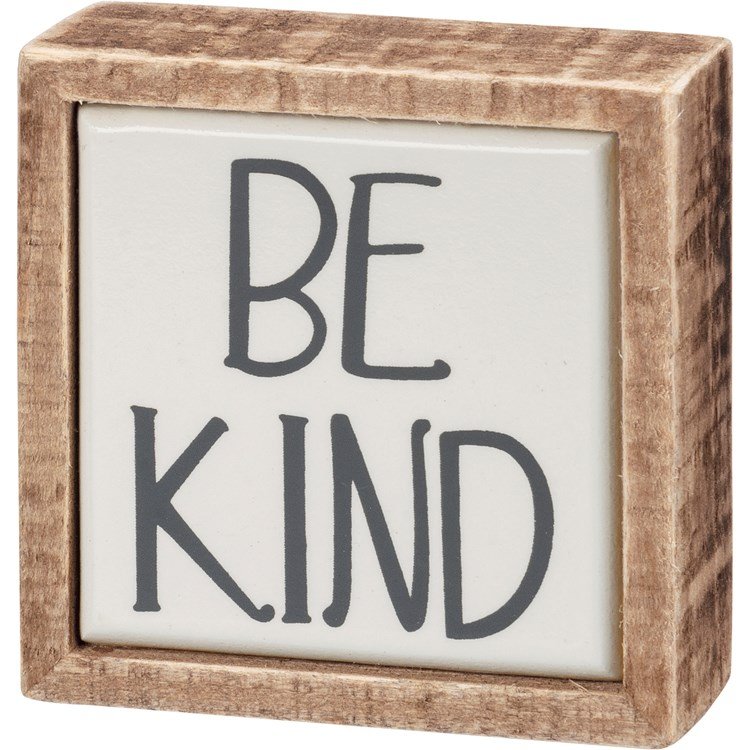 Wooden framed mini sign with white background and dark gray text that reads "BE KIND".