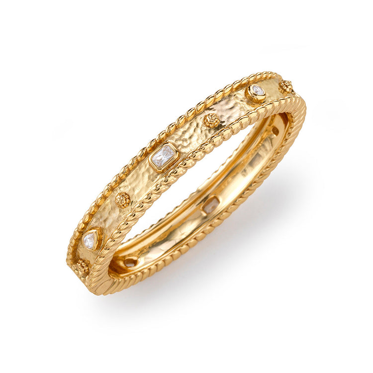 Hinged bangle bracelet in clear cubic zirconia stones set on an 18K gold over brass band.