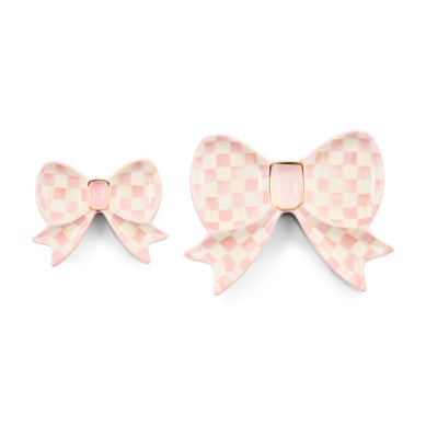 Set of two pink and white checkered ceramic bow trinket dishes with gold lustre accents.