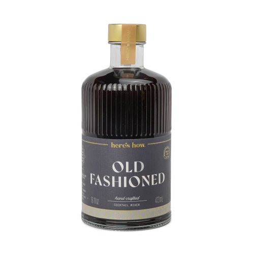 Clear fluted glass bottle with gold foil label reading Here's How Cocktail Mixer
