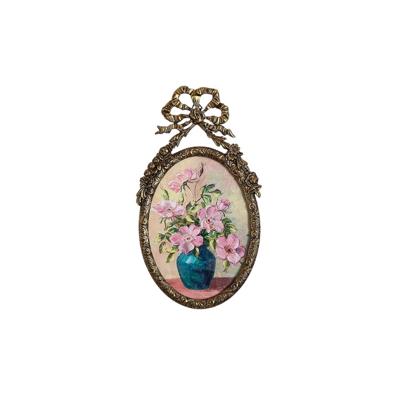 Oval antique pewter frame with bow and floral detailing, featuring a painting of pink flowers.