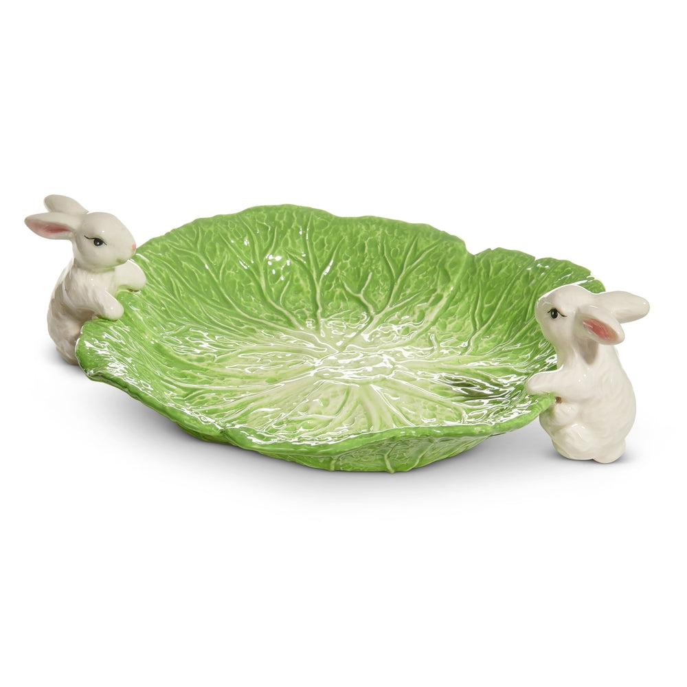 Ceramic bowl with white bunny figures on a green cabbage leaf pattern.