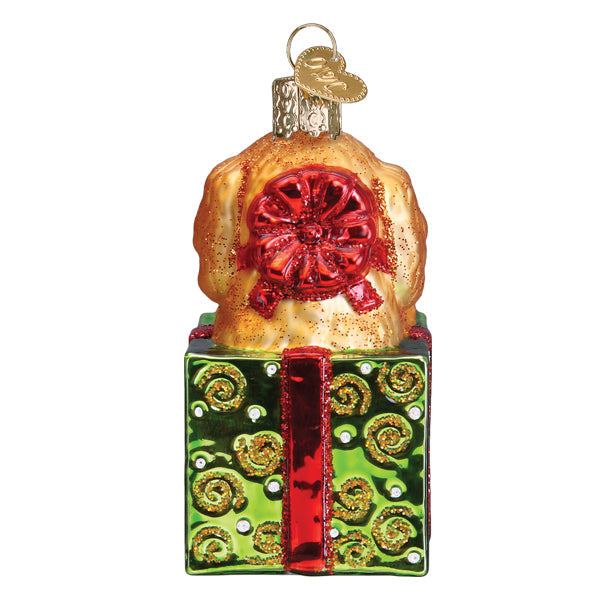 Doodle Puppy Surprise Ornament featuring a golden dog in a green gift box with a red bow.