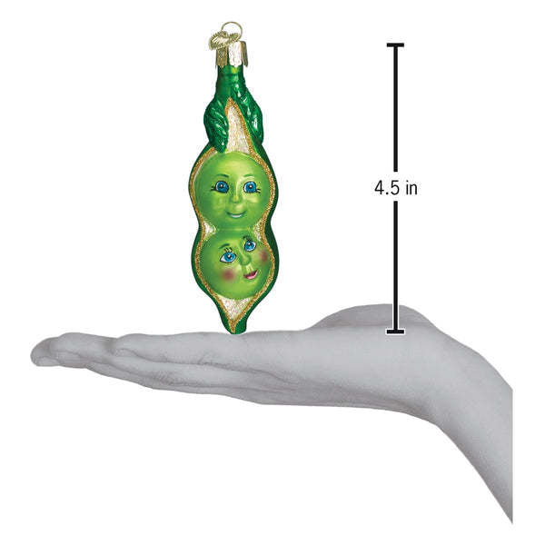 Mouth-blown glass ornament shaped like two peas in a pod with hand-painted silver accents and glitter finish.