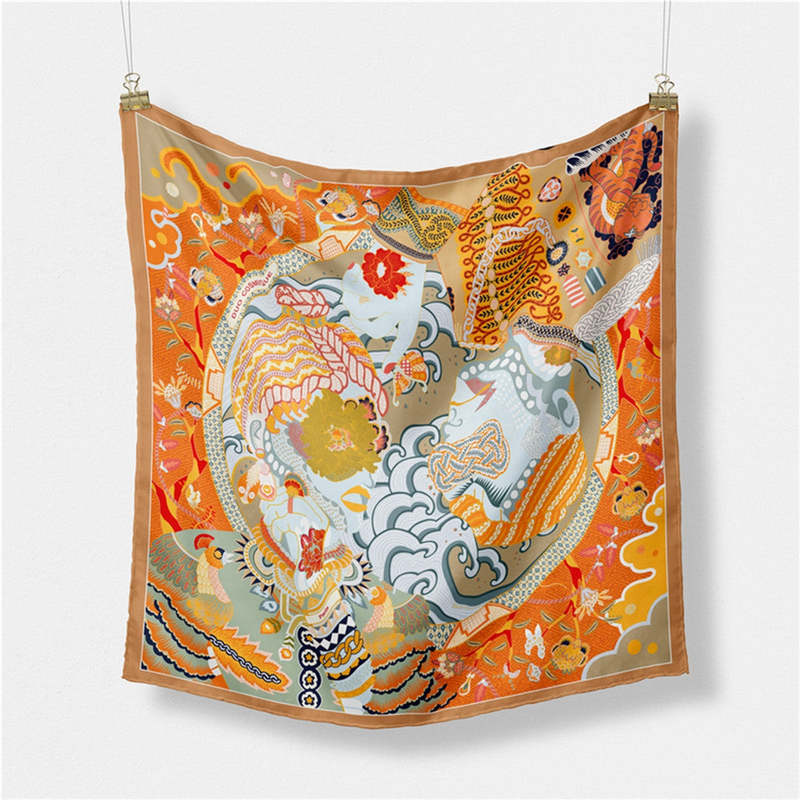 Twilled Satin Mini Scarf with intricate orange, gold, and blue patterns hanging from clips.