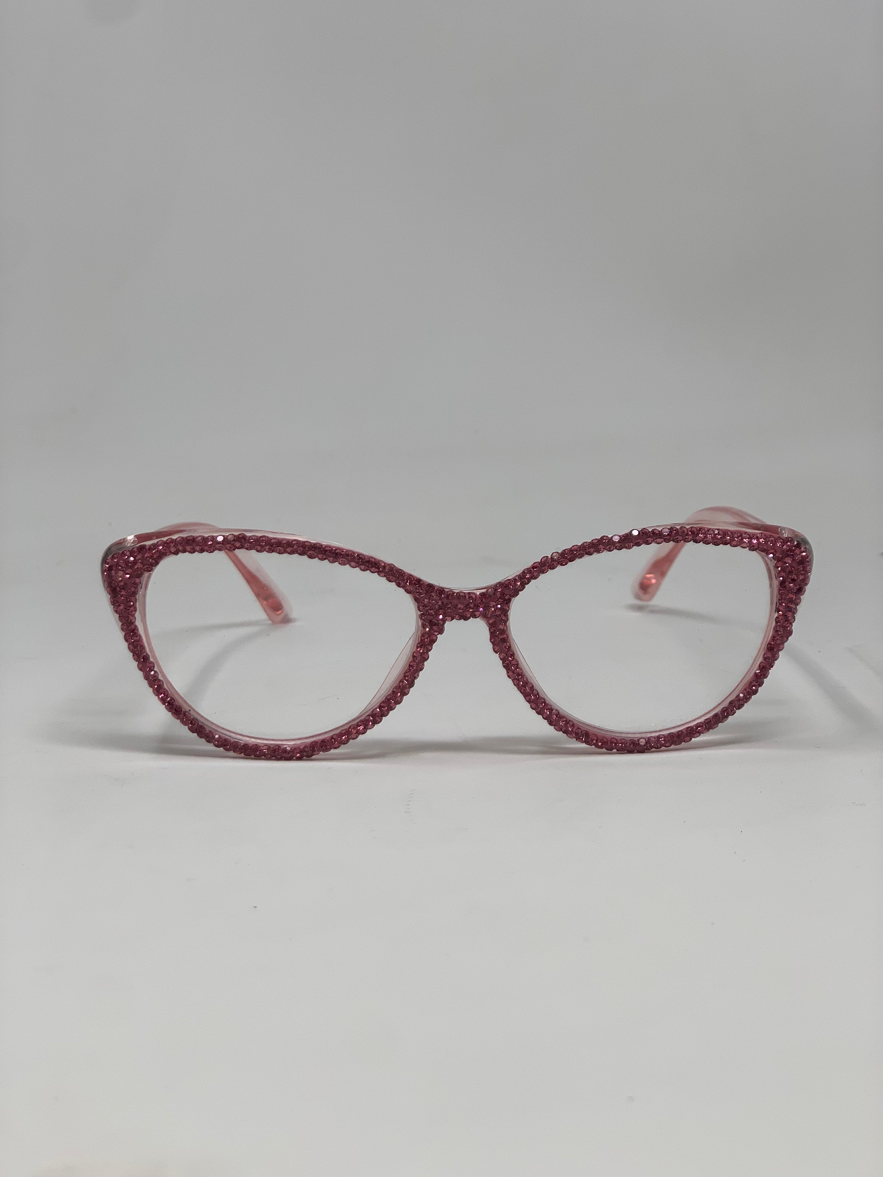Pink cat-eye rhinestone reading glasses with clear lenses on a white background.