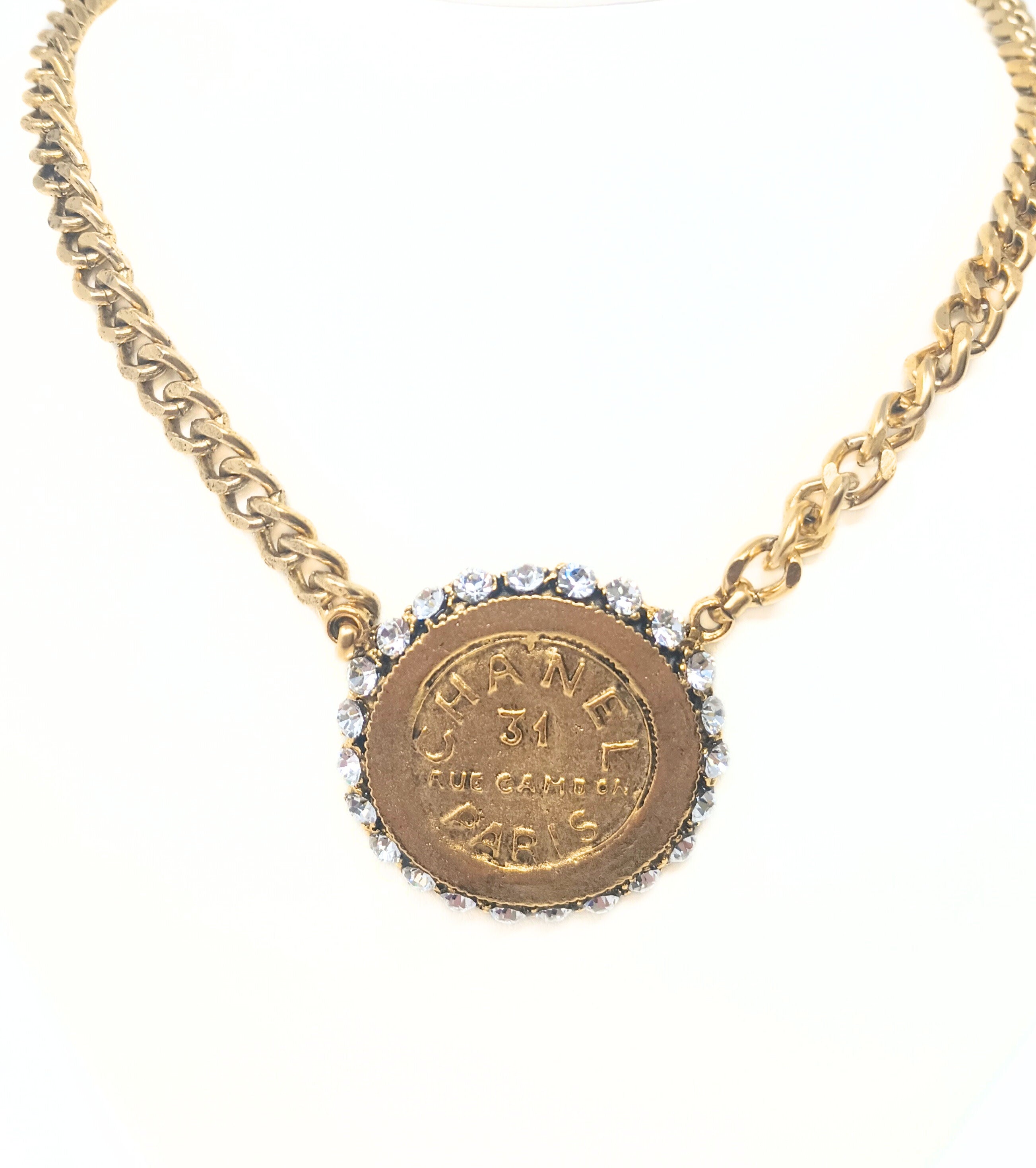 18-inch gold chain necklace featuring a designer-inspired coin pendant with rhinestone border.