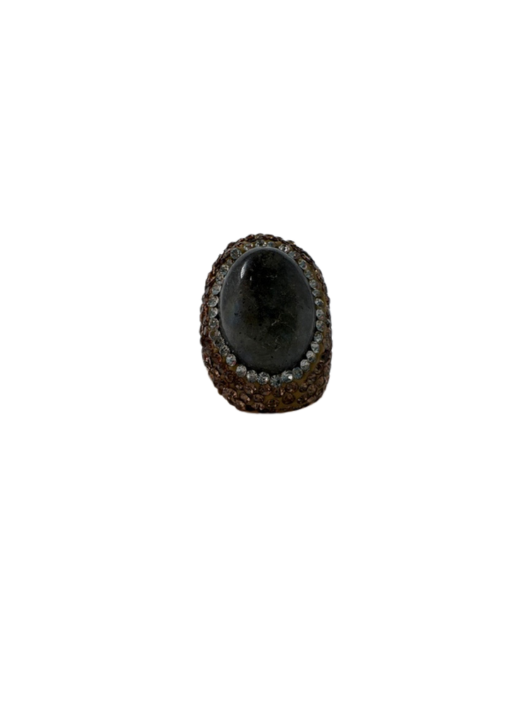 Fashion gemstone ring featuring a large oval dark stone surrounded by clear and amber crystals.