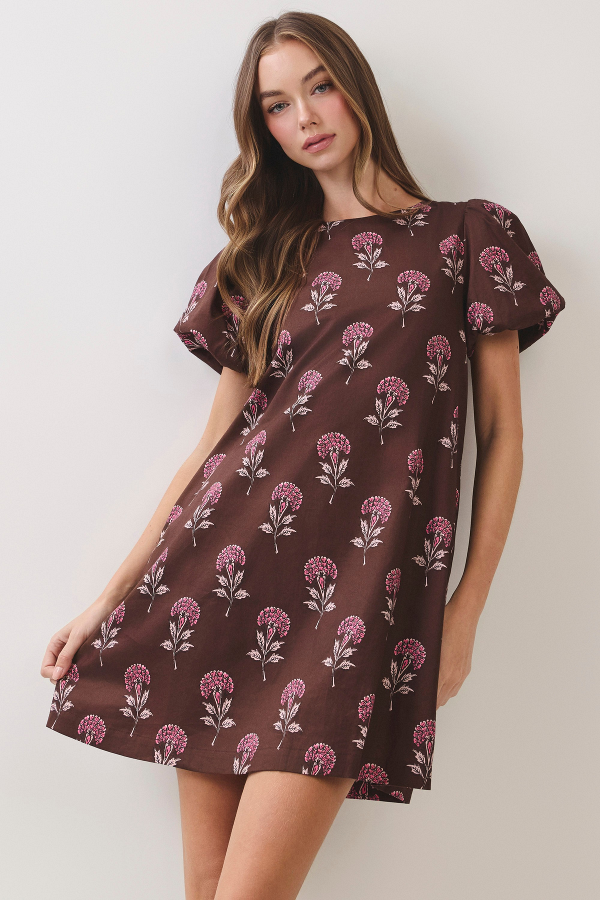 Brown floral print mini dress with round neckline, short puff sleeves, and relaxed A-line fit.