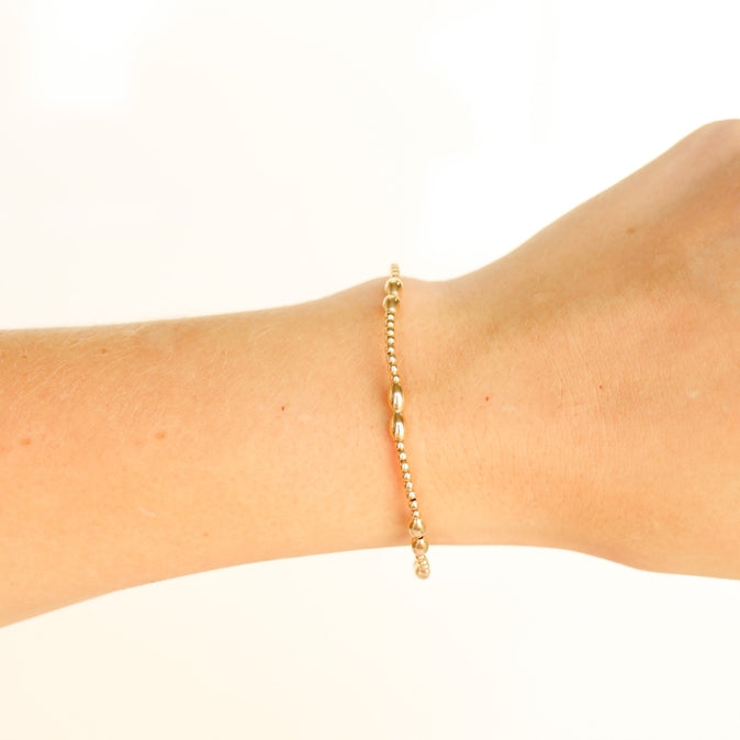 Gold-colored Bella bracelet featuring a delicate chain link design with small circular accents.