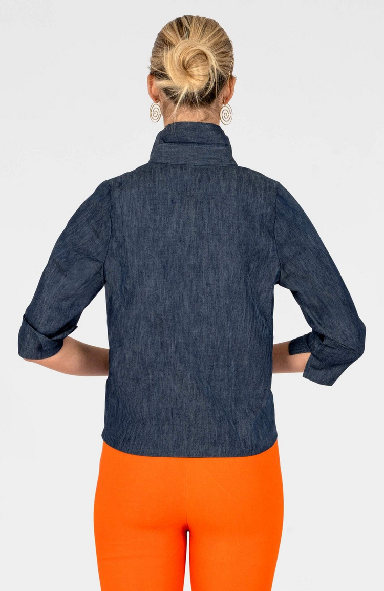 Back view of a woman wearing the dark blue denim Wendy Twist & Shout Top with orange pants.