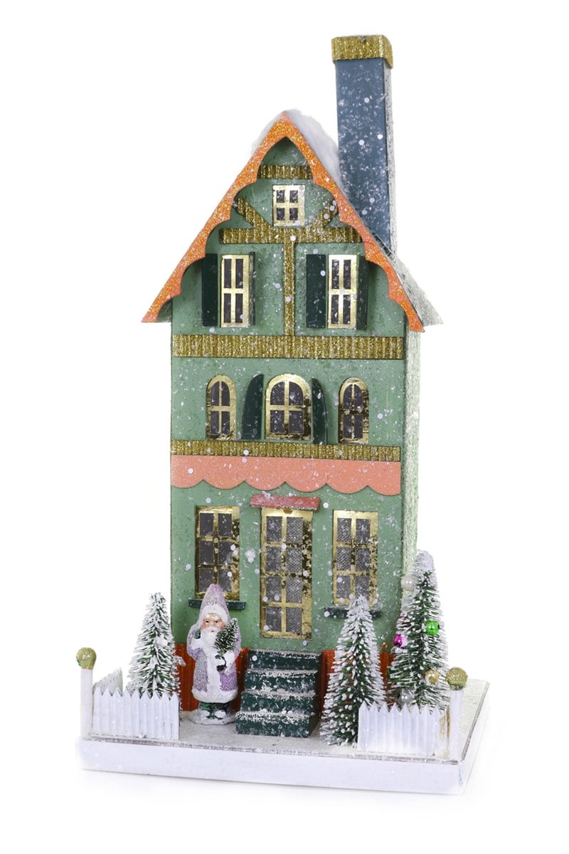 Green glitter house with orange roof, Santa, trees, and white picket fence.
