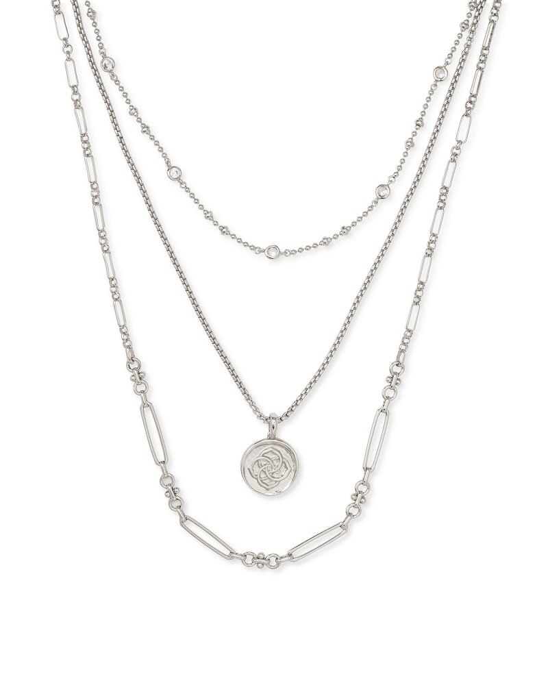 Triple strand necklace in gold featuring a medallion coin pendant on lobster claw closure.