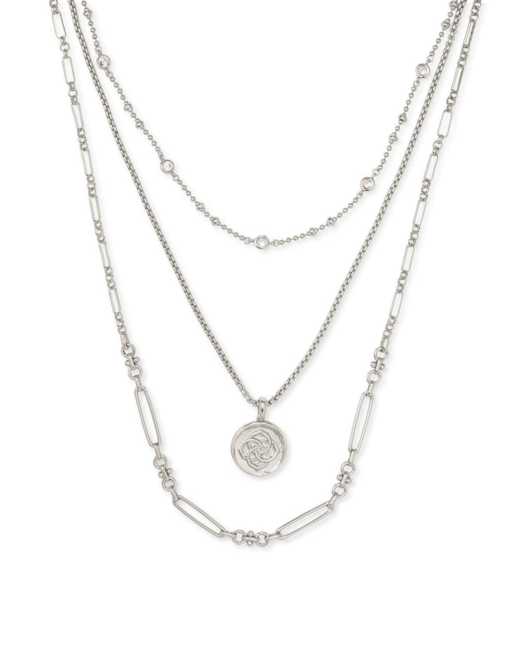 Triple strand necklace in gold featuring a medallion coin pendant on lobster claw closure.