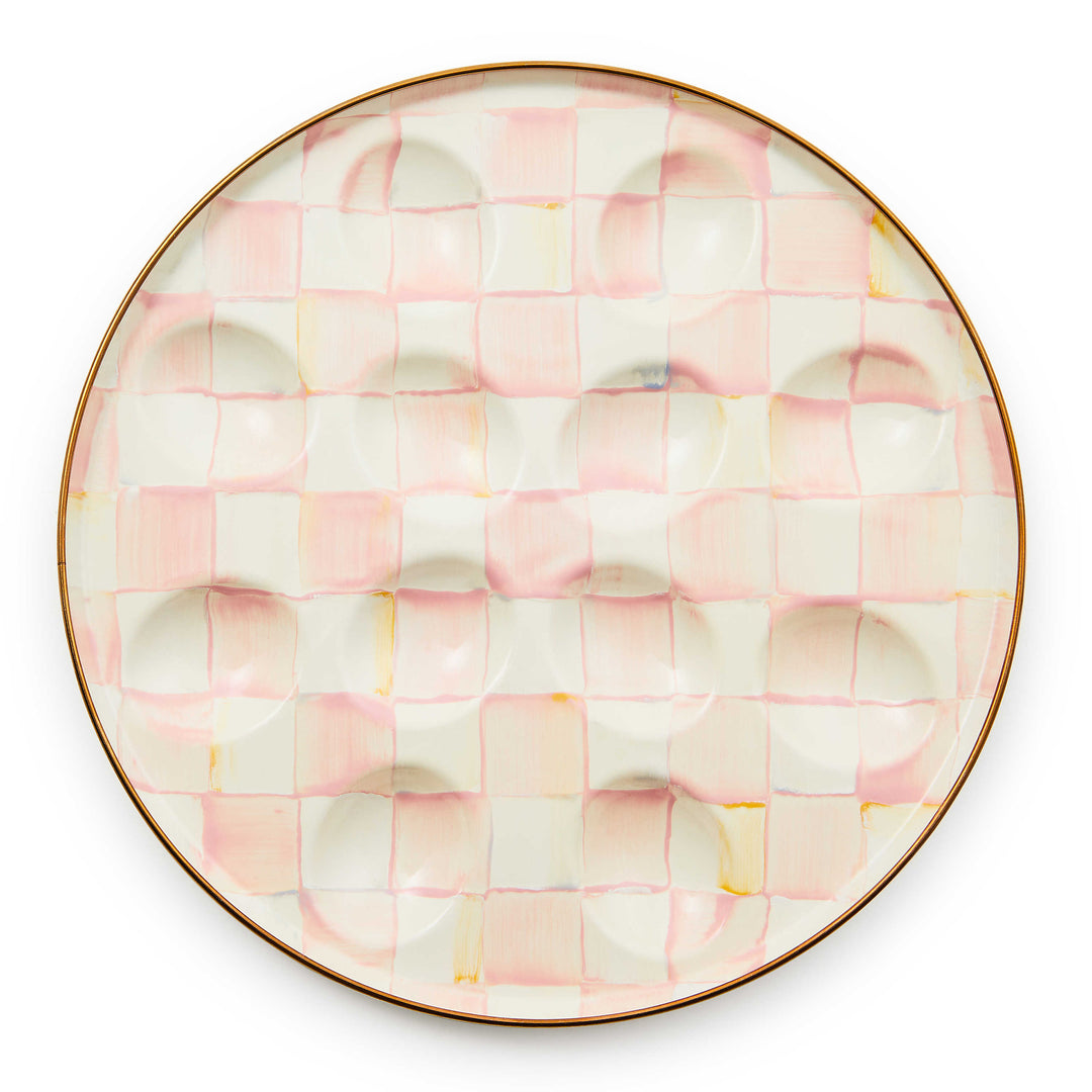 Round pink and white checkered enamel egg plate with 12 indentations and a bronzed rim.