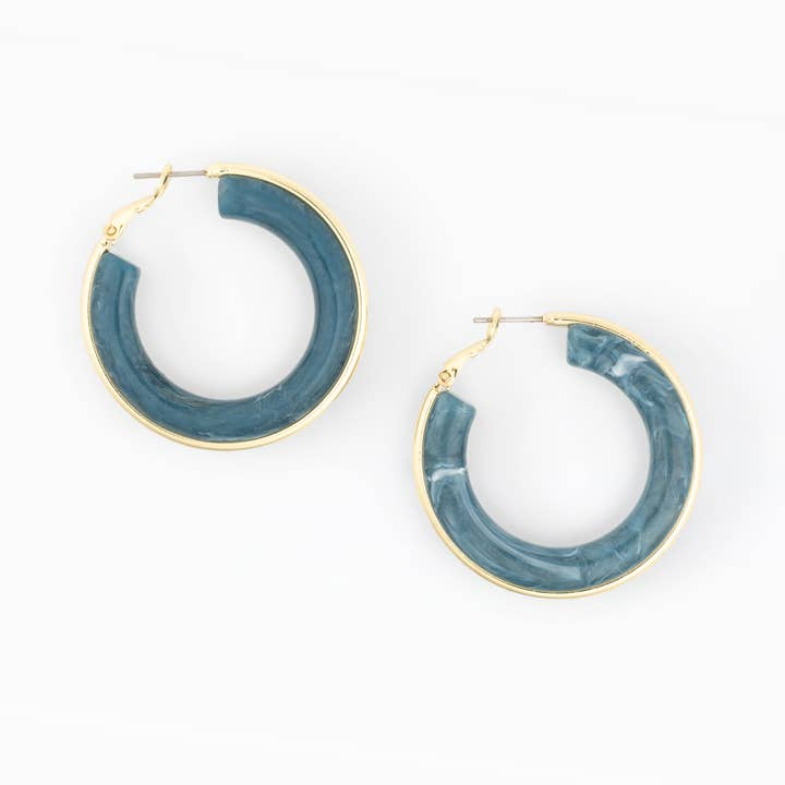 Pair of Esme hoop earrings featuring blue marbled resin and gold-plated brass metal.