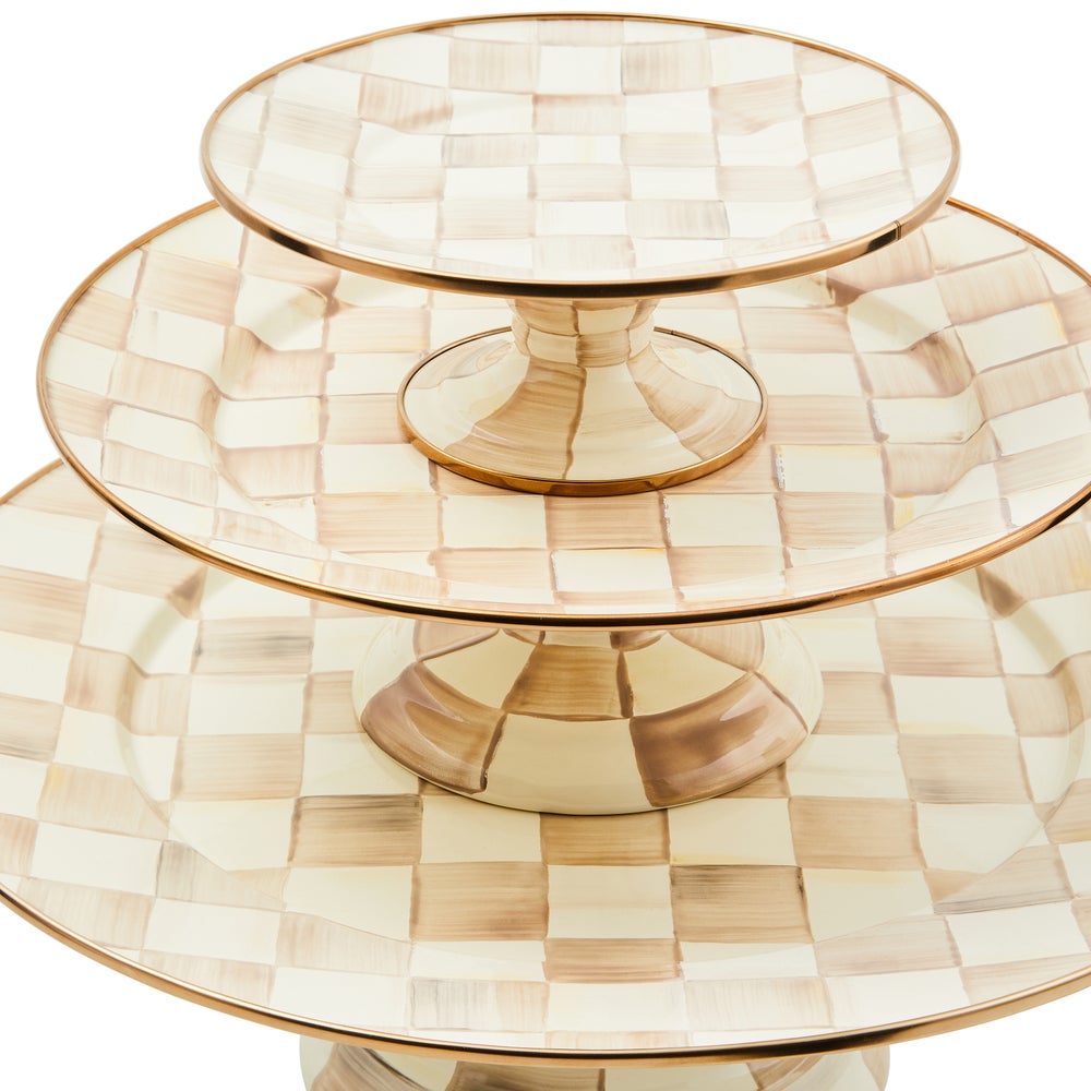 Three-tiered Mocha Check pedestal platters with hand-painted tan and cream checks and bronze rims.