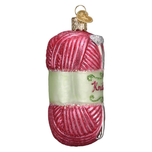Hand-knitted yarn ornament in cream with a textured ribbed pattern.