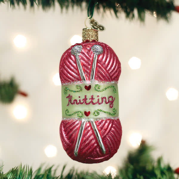 Hand-knitted yarn ornament in cream with a textured spiral pattern.