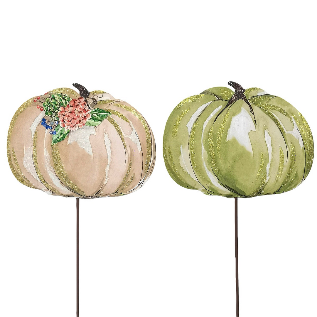 Two decorative pumpkin stakes, one cream with floral accents and one green, both with gold glitter.