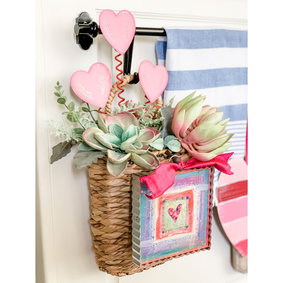 Three heart-shaped metal stakes with a matte finish designed as garden markers.