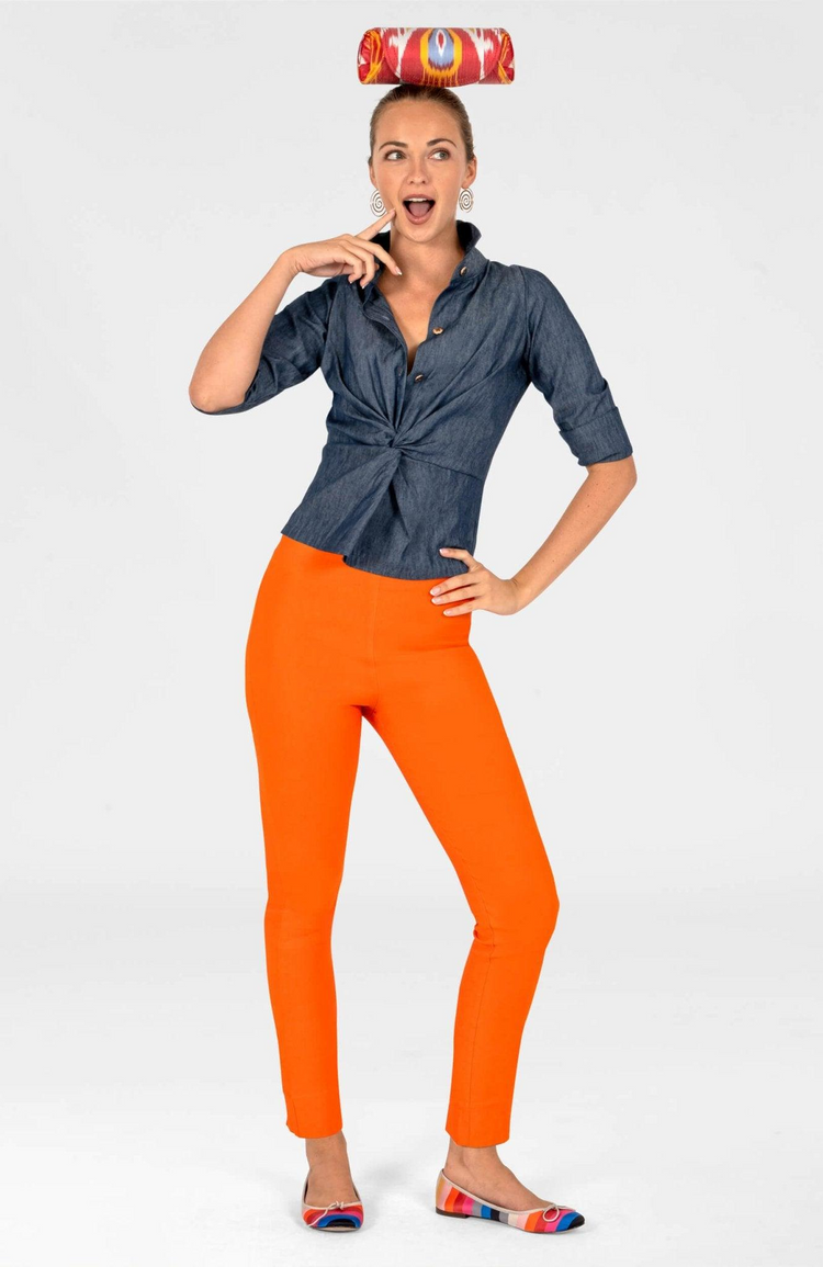 Woman wearing the Wendy Twist & Shout Top in Ring Toss denim with orange pants.