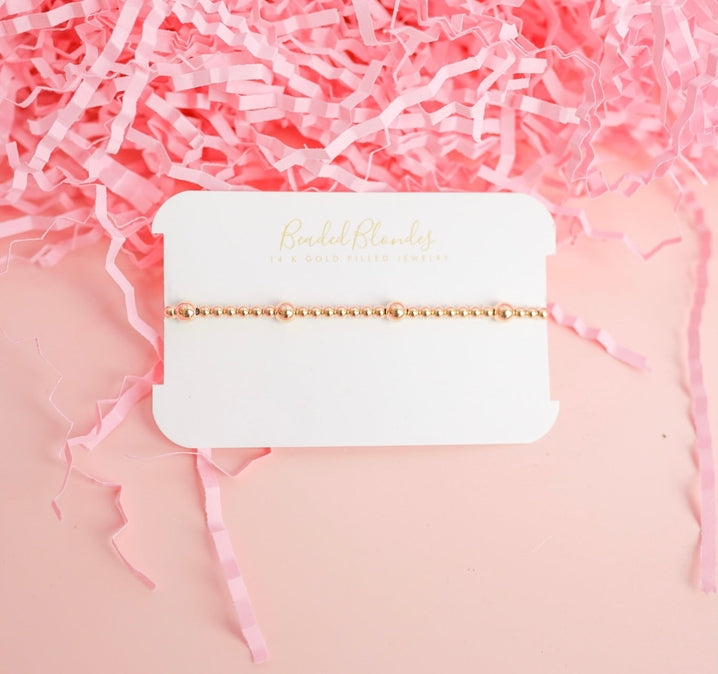 Gold basic bracelet featuring a simple chain link design with polished metal finish.