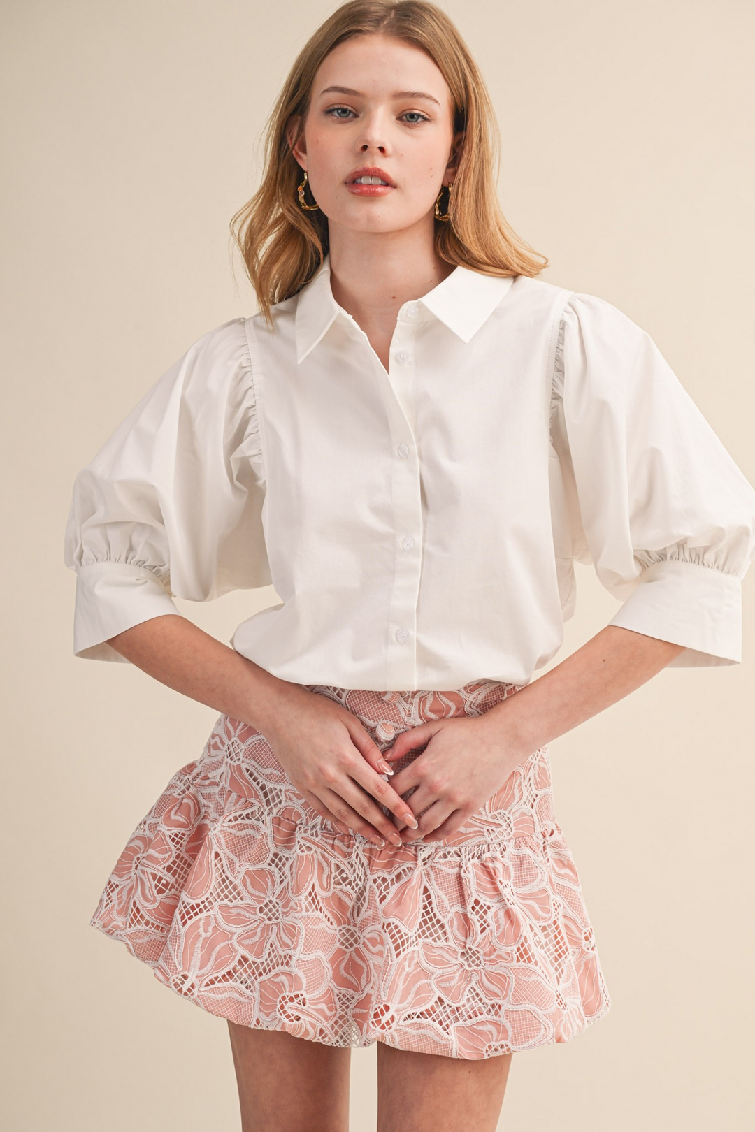 Woman wearing a white Krisha Puff Sleeve Button Down Top with a collared neckline and wide cuffs.